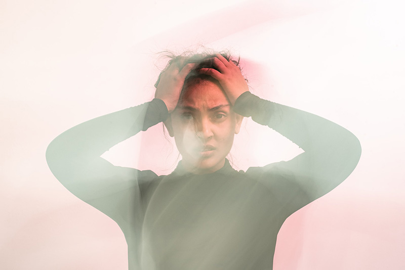 donna con mani nei capelli su sfondo rosa, immagine in movimento, donna stressata