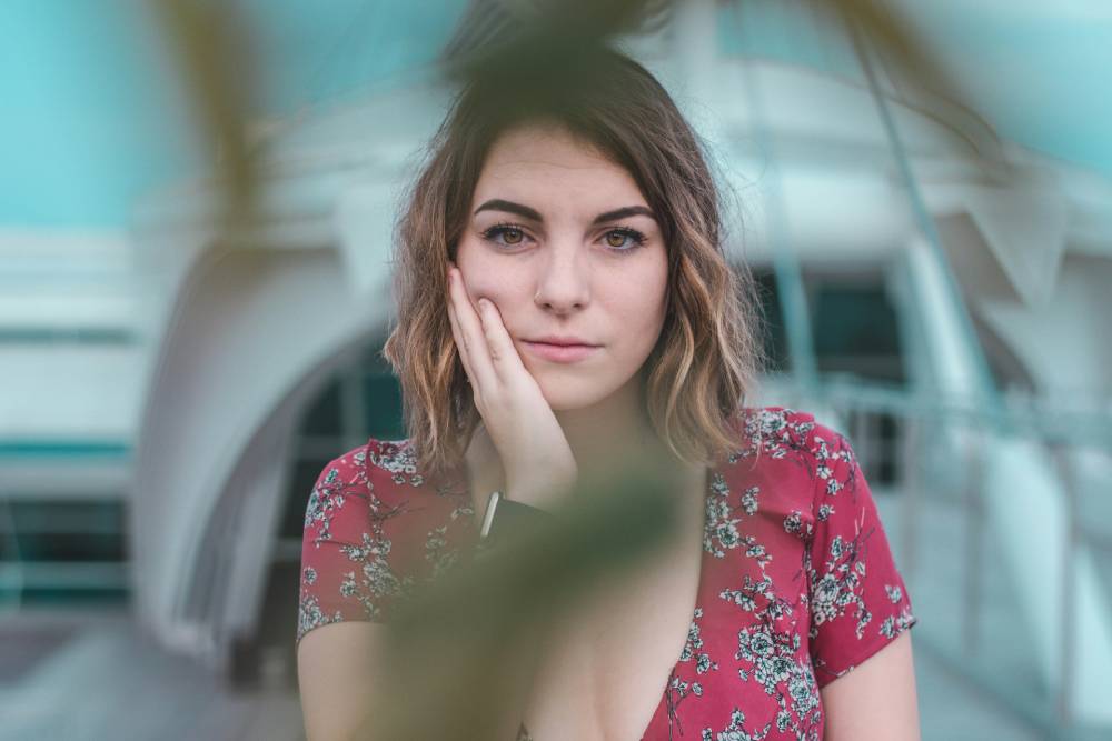 donna in primo piano che appoggia la guancia alla mano