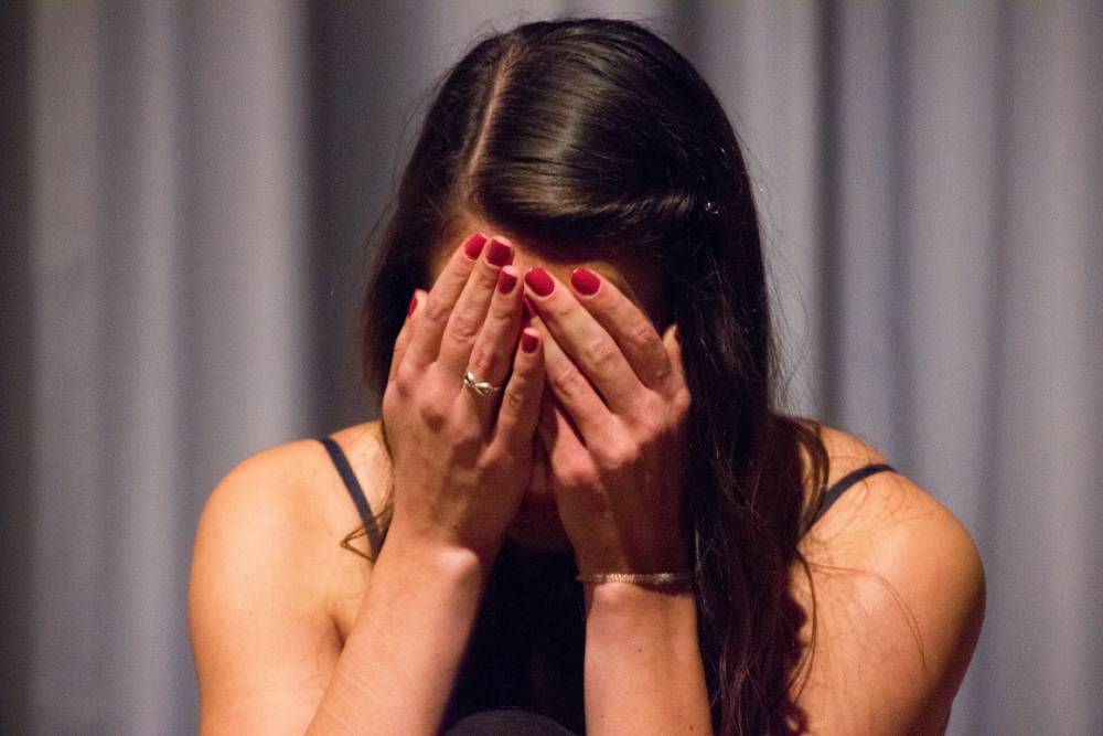 donna che si porta le mani alla faccia e piange