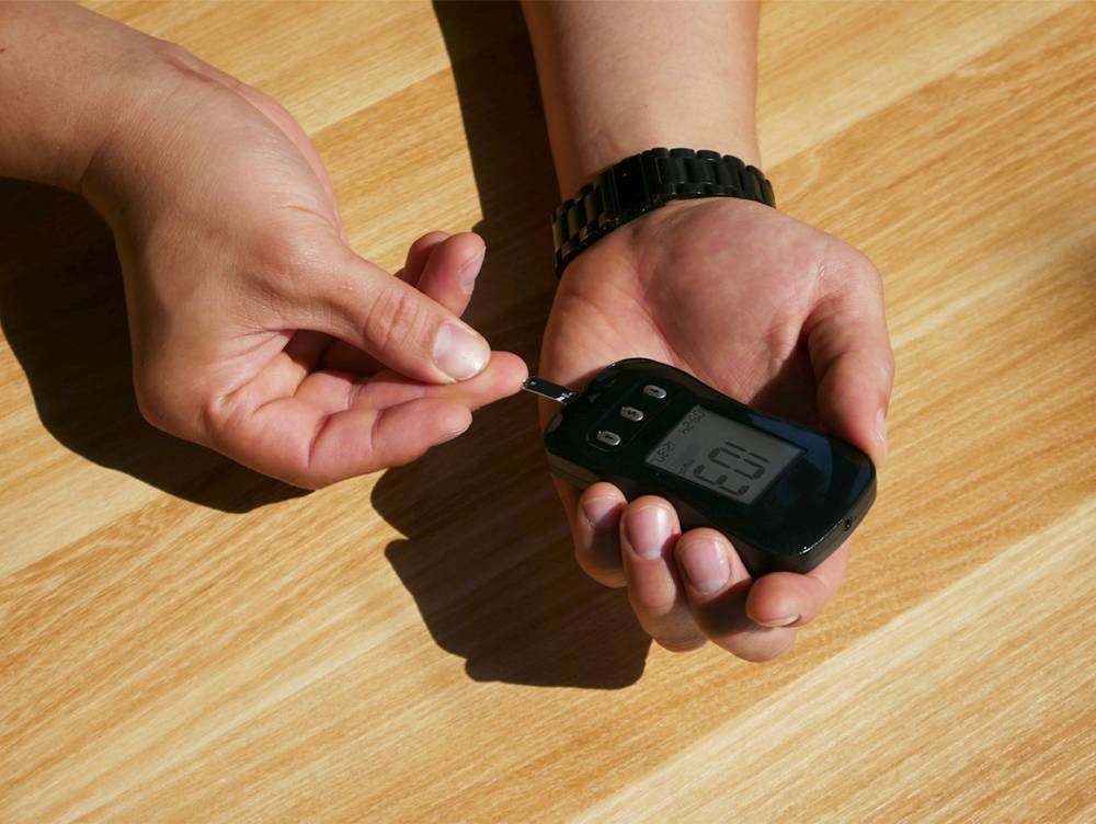 due mani che tengono strumento per misurare insulina