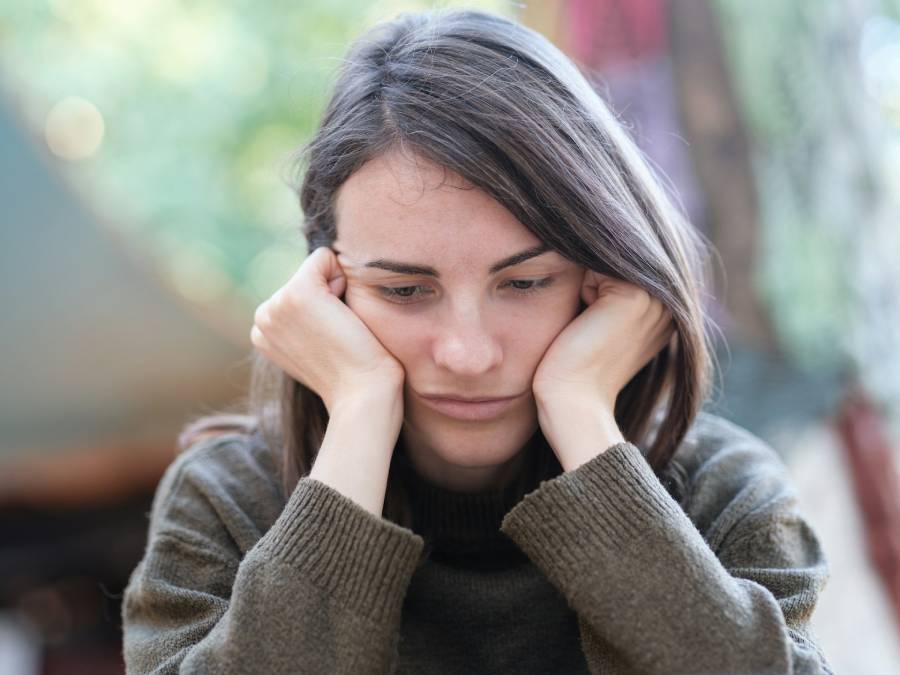 donna con faccia la tra le mani ansiosa