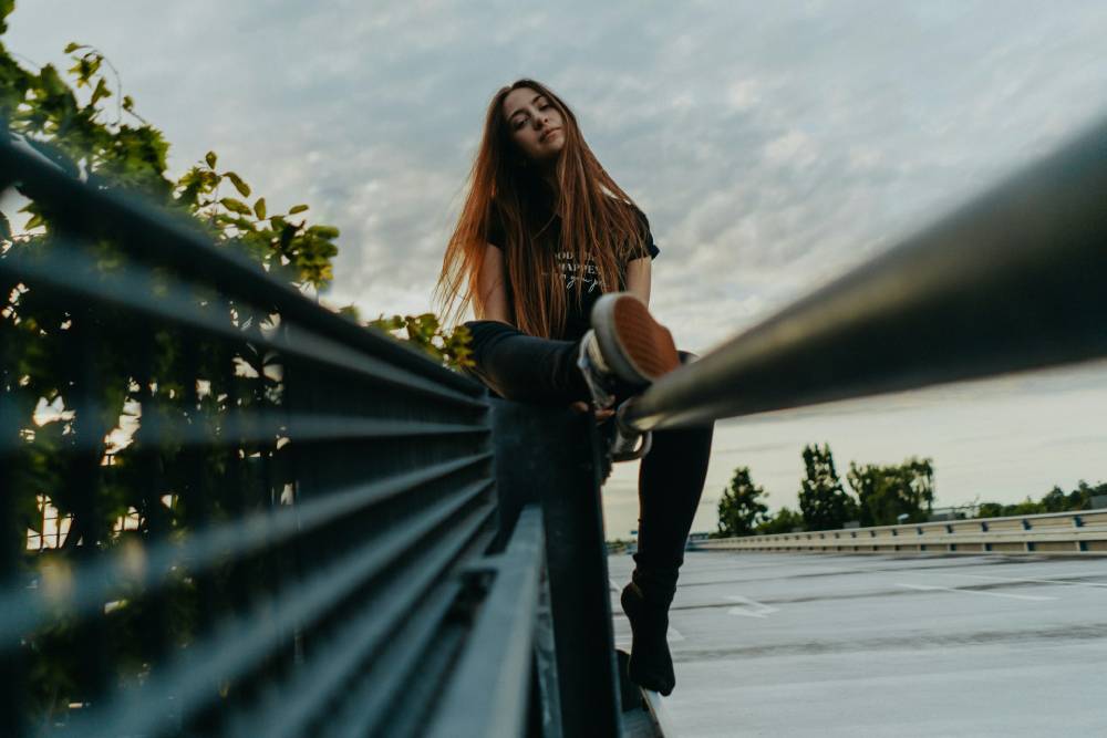 donna che sorride seduta su una staccionata quando sto meglio poi sto peggio